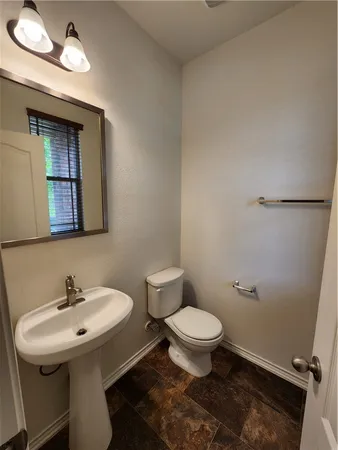 a bathroom with a sink toilet and a mirror