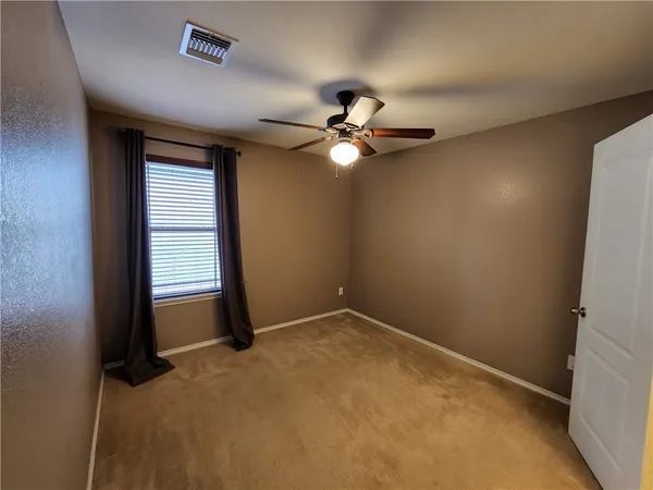 an empty room with windows and fan