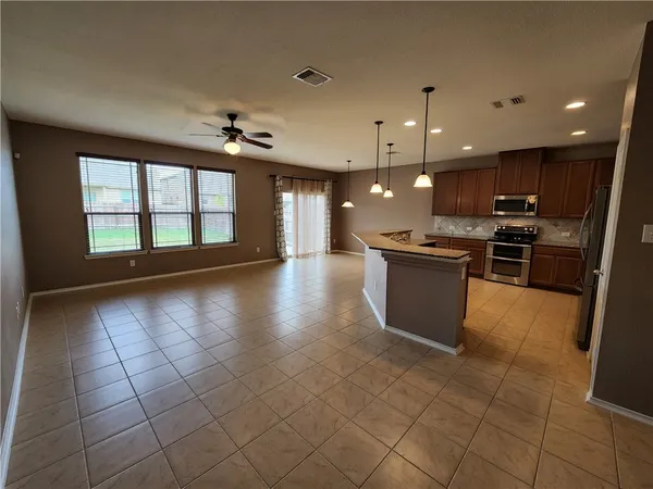 a large kitchen with stainless steel appliances granite countertop a stove a sink and a refrigerator