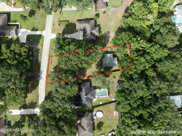 an aerial view of residential house with outdoor space and trees all around