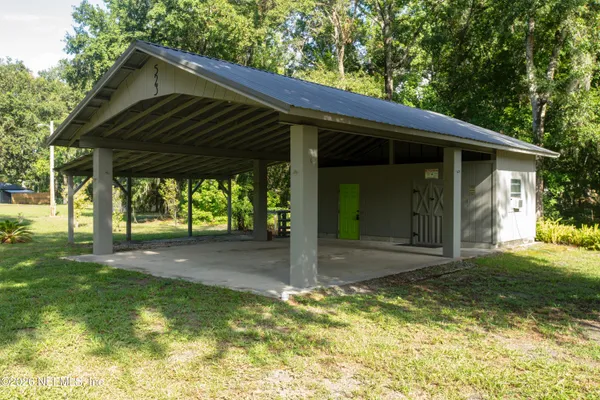 a backyard of a house with large trees and plants