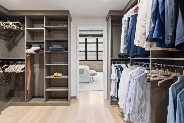 a view of walk in closet with clothes and shoes