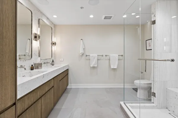 a bathroom with a double vanity sink toilet and shower