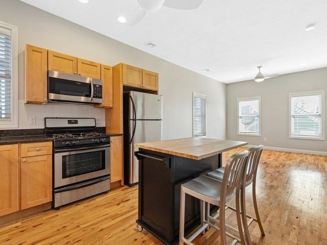 a kitchen with stainless steel appliances granite countertop a stove and a refrigerator