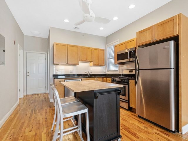 a kitchen with a refrigerator a sink and cabinets