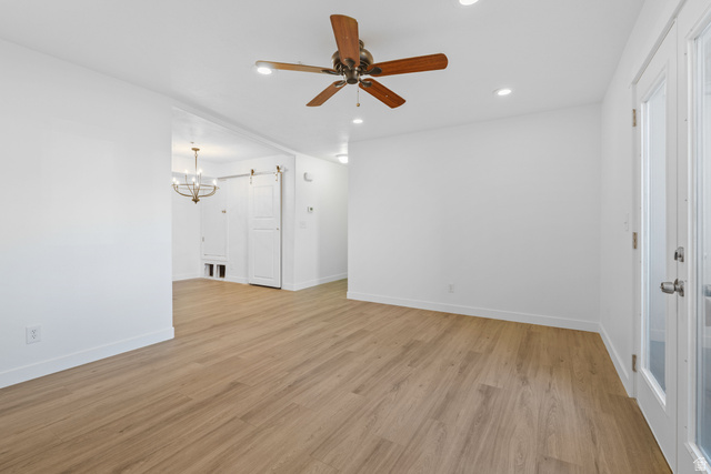 8204 North Cedar Springs Road, Unit 2 Eagle Mountain, UT 84005 - Photo 1 of 17 Unfurnished living room with ceiling fan, light wood-style flooring, and hanging lights