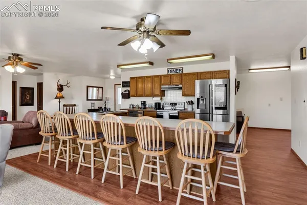 a view of a dining room with furniture a chandelier and wooden floor