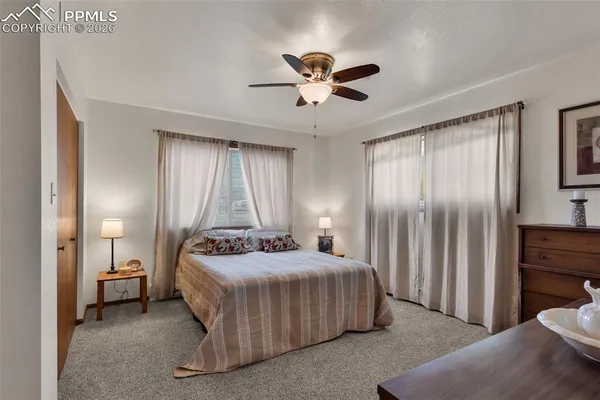 a bedroom with a bed and large windows