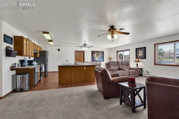 a living room with furniture and a kitchen view