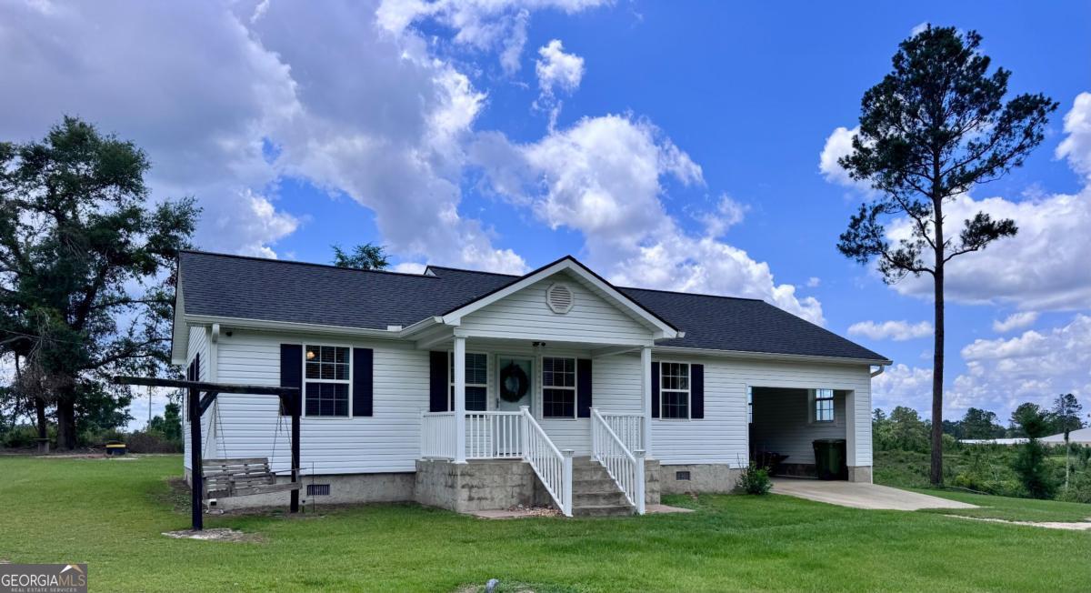 309 Ralph Wommack Road Hazlehurst, GA 31539 - Photo 1 of 1 a front view of a house with a garden and yard