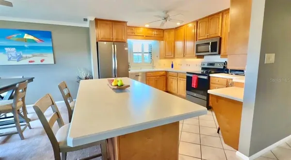 a kitchen with a sink a counter top space cabinets stainless steel appliances and a window