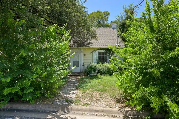 a view of a house with a yard and large trees