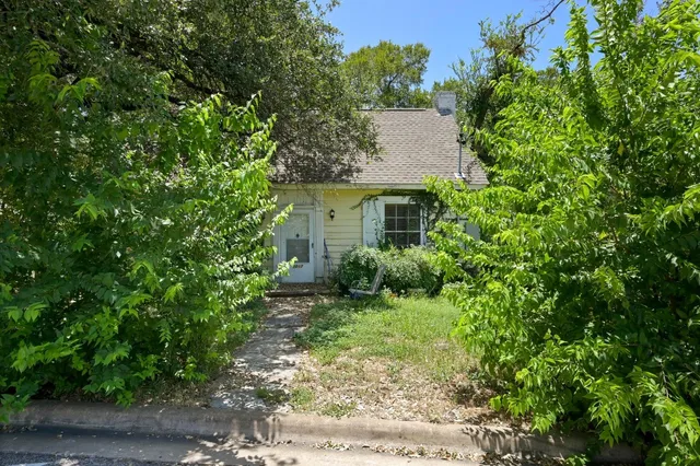 a view of a house with a yard and large trees