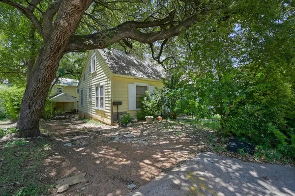 a view of a house with a tree in front of it