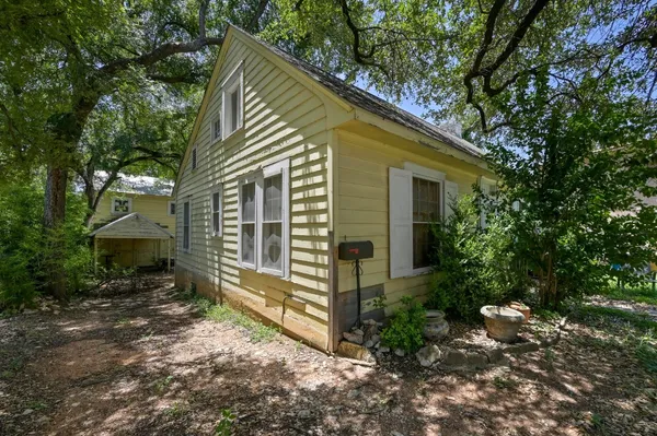 a view of a house with a yard and sitting area