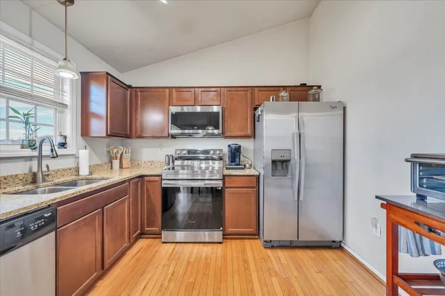 a living room with furniture kitchen view and a chandelier