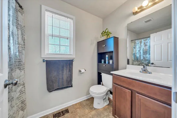 a bedroom with a bed and a dresser next to a window