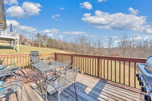 a view of a patio with table and chairs with wooden floor and fence