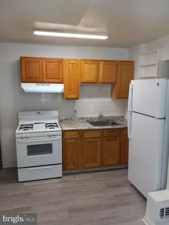 a kitchen with granite countertop a refrigerator stove and sink