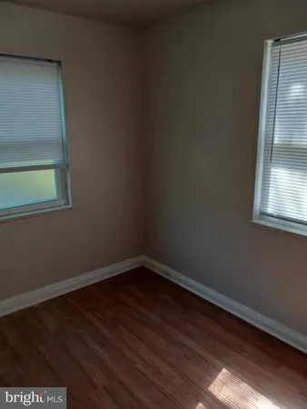 a view of a small space with wooden floor and a window