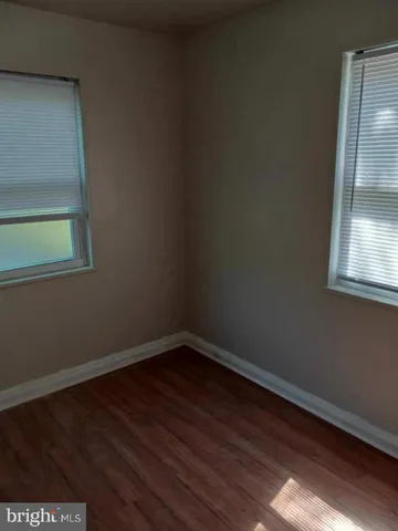 a view of a small space with wooden floor and a window