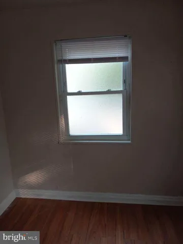a view of a small space with wooden floor and a window