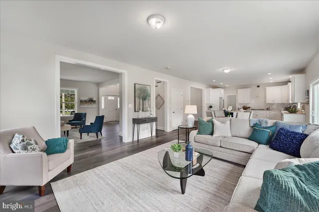 a living room with furniture and view of kitchen