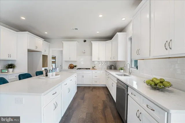 a kitchen with white cabinets appliances and sink