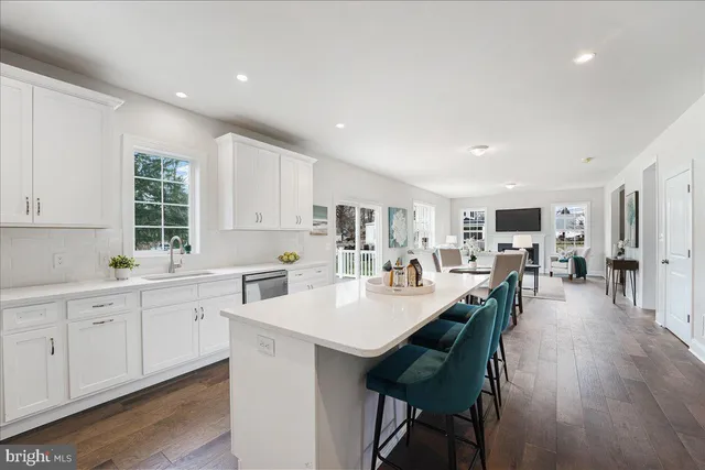 a large white kitchen with lots of counter space and breakfast area