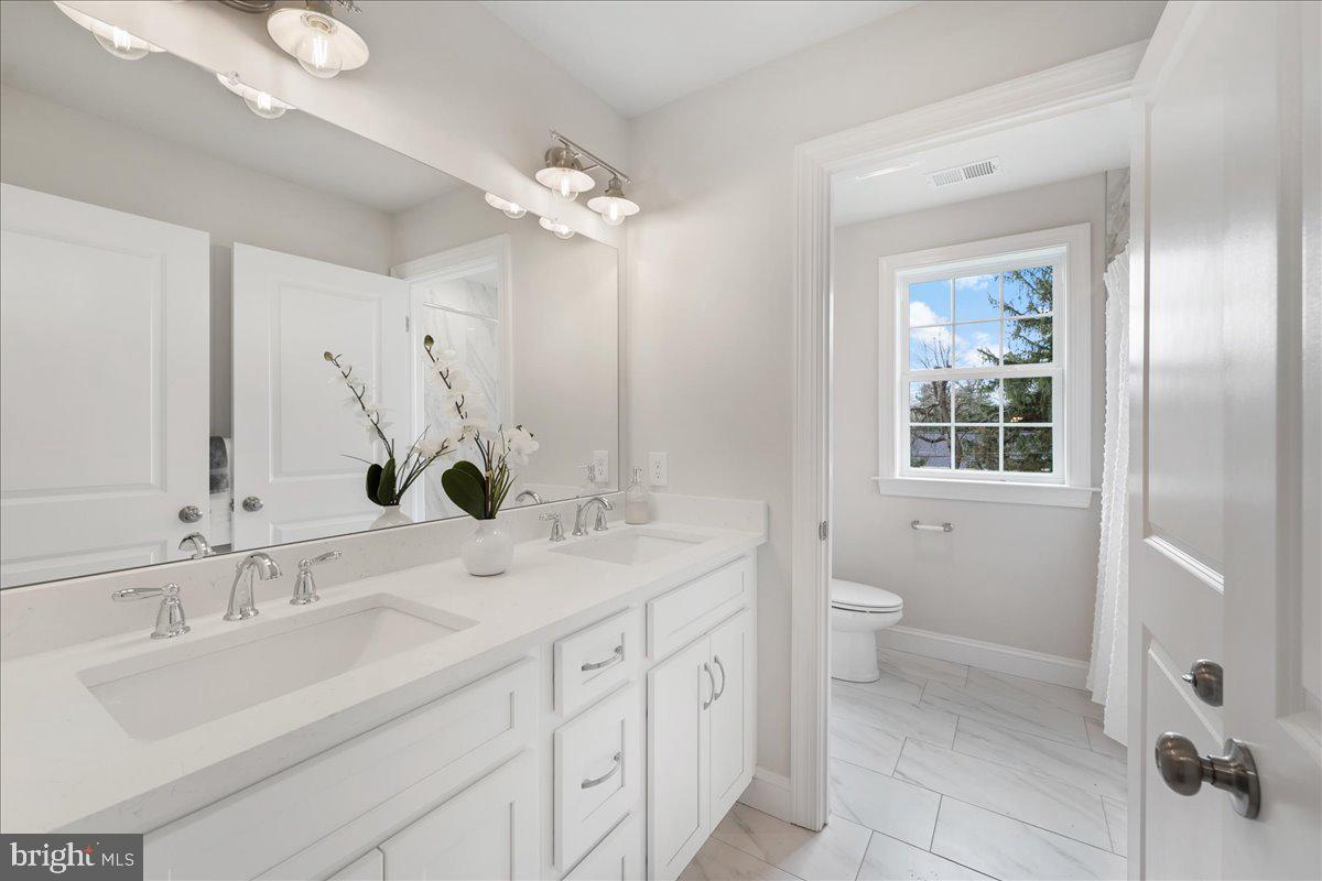 1240 Gradyville Road Glen Mills, PA 19342 - Photo 29 of 39 a bathroom with a sink double vanity and a mirror