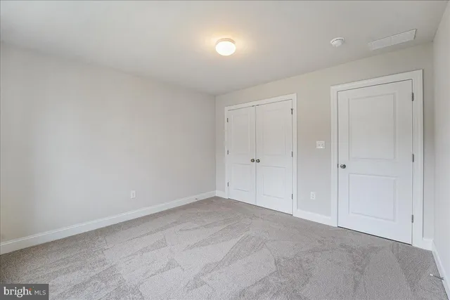 a spacious bedroom with a bed and a large window