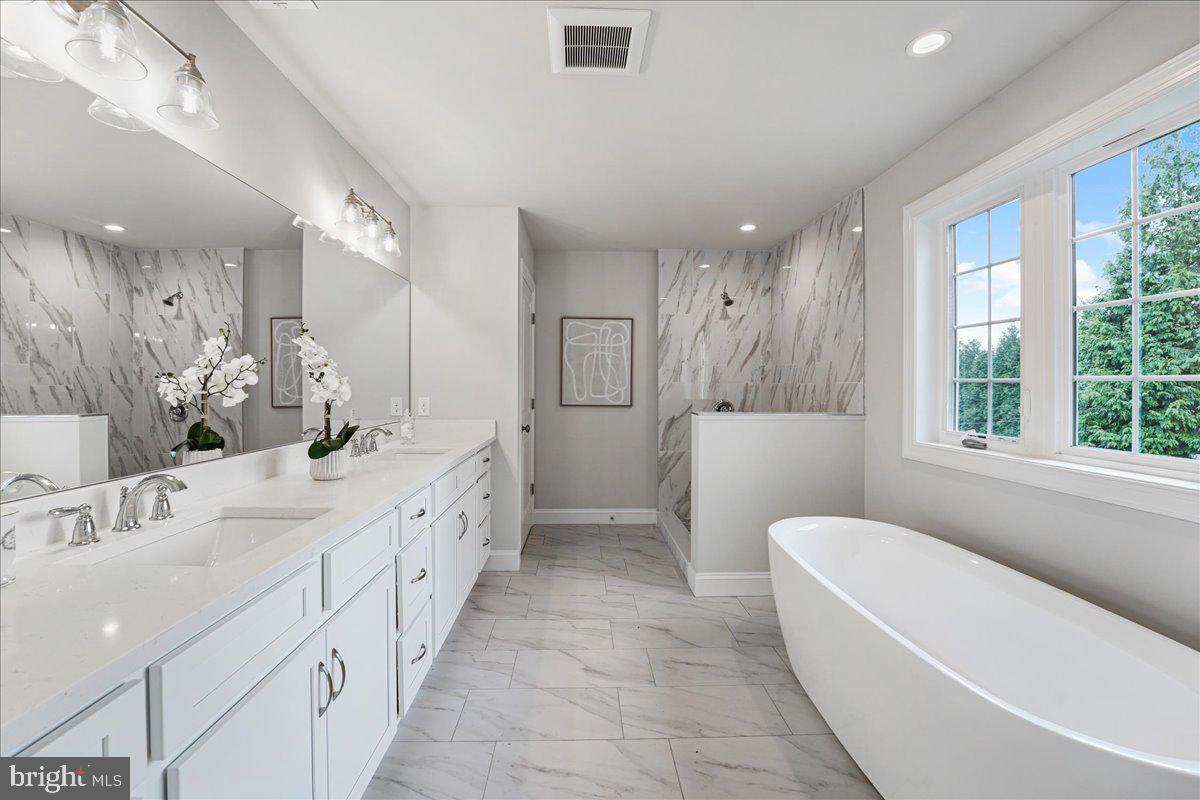 1240 Gradyville Road Glen Mills, PA 19342 - Photo 36 of 39 a bathroom with a double vanity sink a toilet a shower and a large mirror