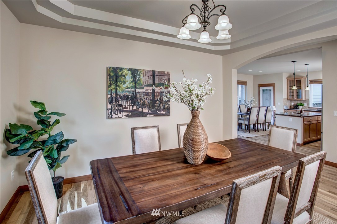 3811 222nd Place Southeast Bothell, WA 98021 - Photo 14 of 35 a view of a dining room with furniture a chandelier and wooden floor