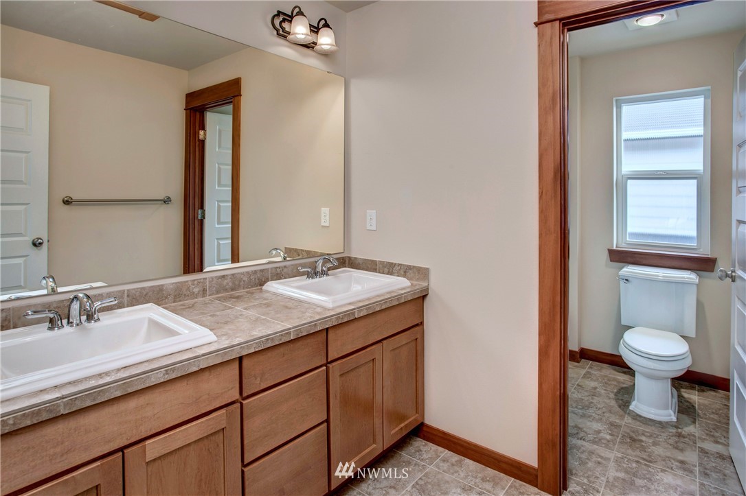 3811 222nd Place Southeast Bothell, WA 98021 - Photo 24 of 35 a bathroom with a sink a toilet and a mirror