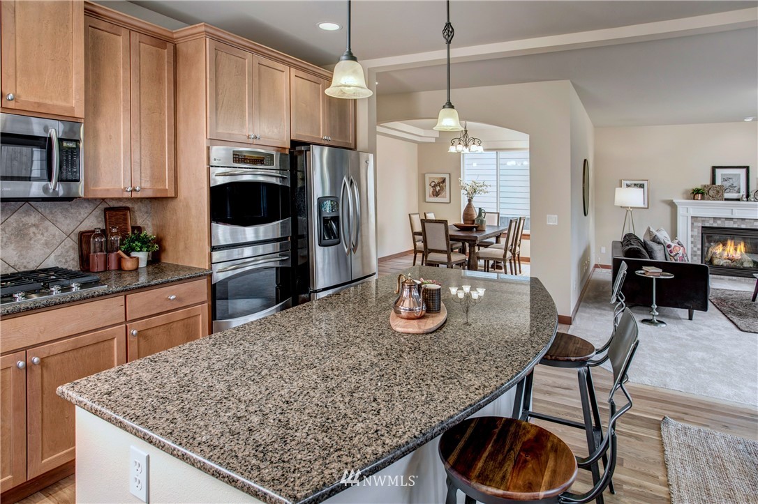 3811 222nd Place Southeast Bothell, WA 98021 - Photo 7 of 35 a kitchen with stainless steel appliances granite countertop a kitchen island hardwood floor sink stove dining table and chairs