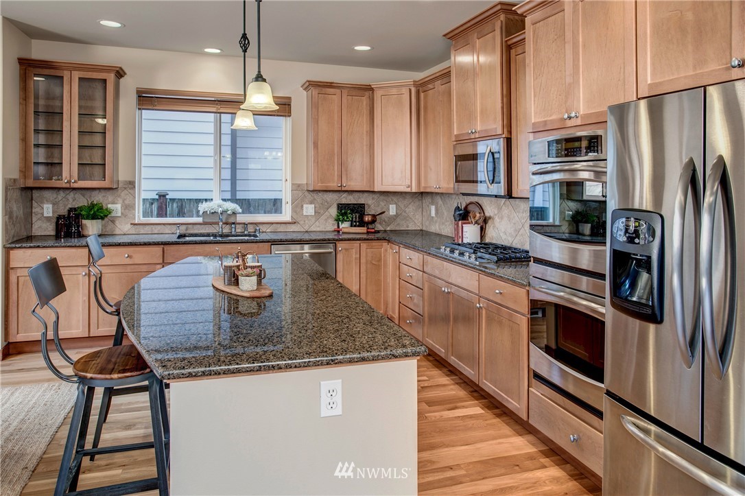 3811 222nd Place Southeast Bothell, WA 98021 - Photo 9 of 35 a kitchen with stainless steel appliances granite countertop a sink a stove and a refrigerator