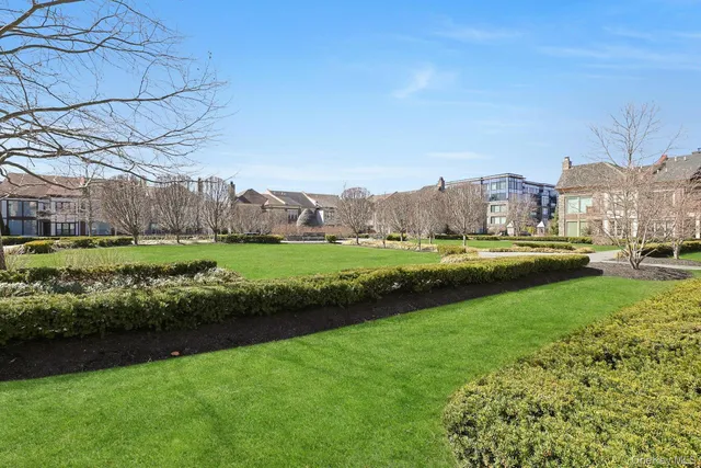 a view of a house with a big yard and a fountain