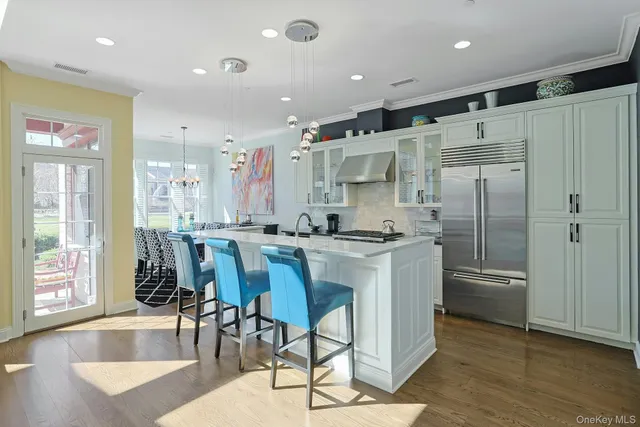 a kitchen with stainless steel appliances granite countertop a refrigerator and a stove top oven