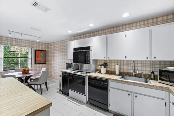 a kitchen with stainless steel appliances kitchen island granite countertop a sink and a stove