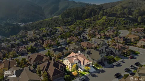 a front view of a house with a yard and a large tree