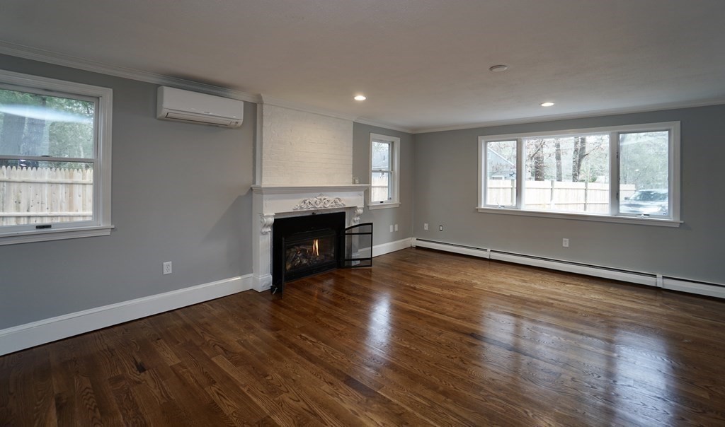 44 Avalon Circle Barnstable, MA 02655 - Photo 25 of 42 an empty room with wooden floor fireplace and windows