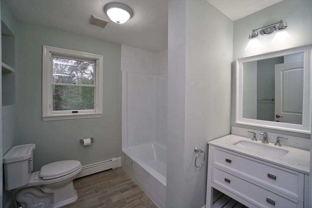 44 Avalon Circle Barnstable, MA 02655 - Photo 9 of 42 a bathroom with a toilet a sink a mirror a window and vanity