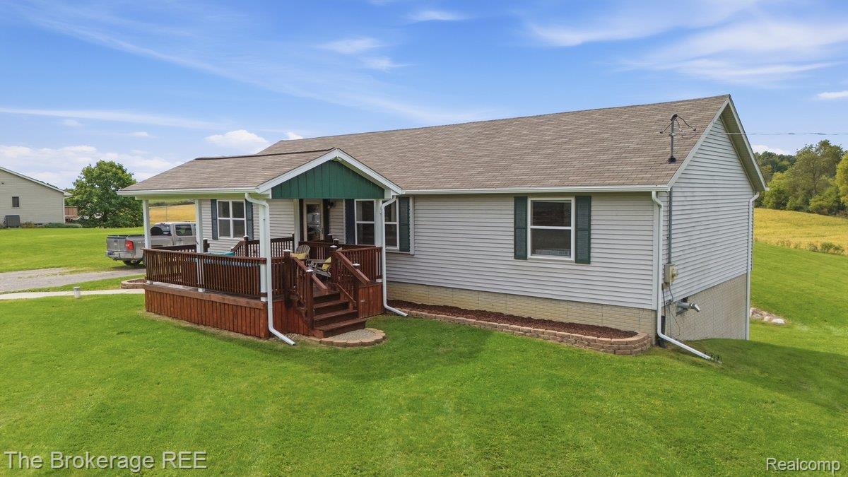 2422 South Henderson Road Davison, MI 48423 - Photo 6 of 53 Exterior featuring light-colored siding, dark green shutters, and a covered front porch with stained wood railing