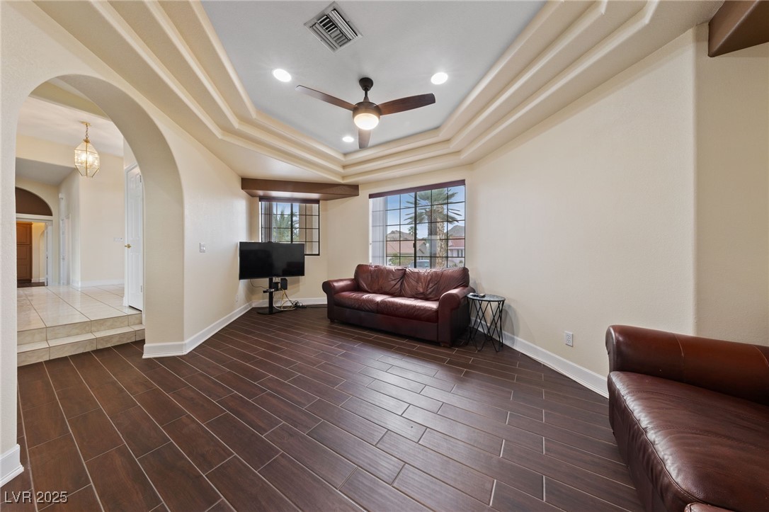 1056 Calico Ridge Drive Henderson, NV 89011 - Photo 11 of 67 Living area featuring visible vents, baseboards, a raised ceiling, arched walkways, and a ceiling fan