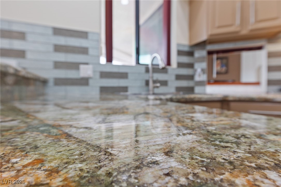 1056 Calico Ridge Drive Henderson, NV 89011 - Photo 18 of 67 Interior details featuring light stone countertops, a sink, and backsplash
