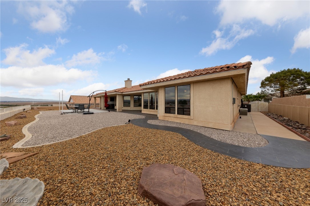 1056 Calico Ridge Drive Henderson, NV 89011 - Photo 46 of 67 Rear view of property featuring a fenced backyard, stucco siding, a patio, a tile roof, and a chimney