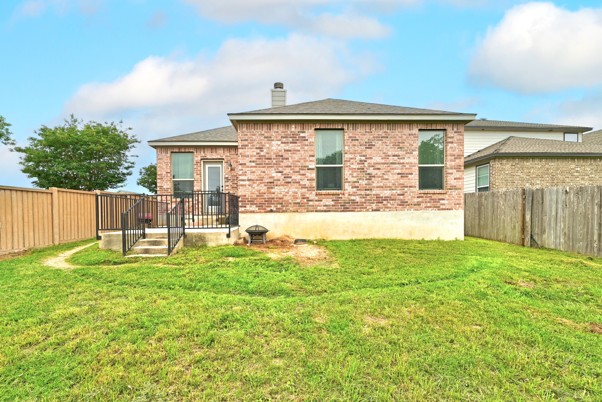 1621 Dragonfly Loop Bastrop, TX 78602 - Photo 25 of 27 Expansive grassy yard with a brick exterior