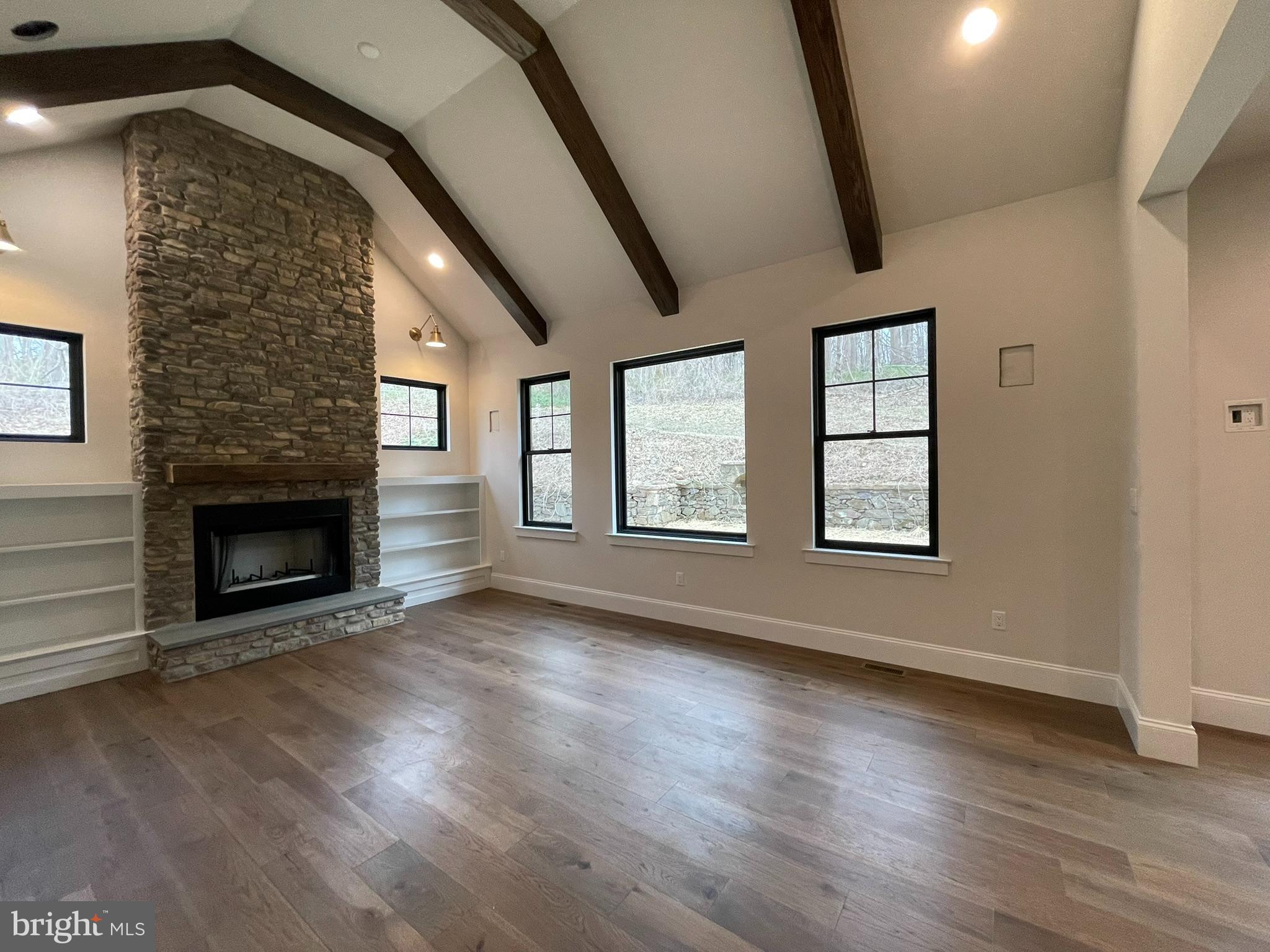 380 Zynn Road Downingtown, PA 19335 - Photo 19 of 53 an empty room with wooden floor fireplace and windows