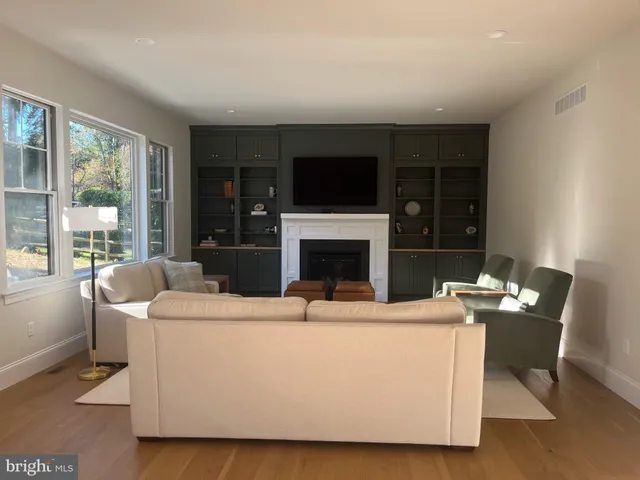 a living room with furniture a flat screen tv and a fireplace