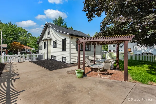 a view of a house with backyard and sitting area
